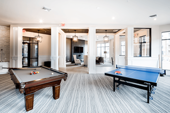 A room with a pool table and a ping pong table.